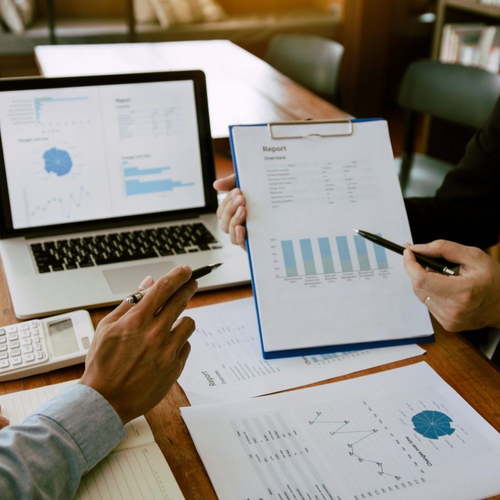 Two business partnership coworkers analysis strategy with discussing a financial planning graph and